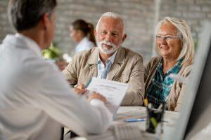 Image of a senior couple talking with a medical professional about healthcare coverage