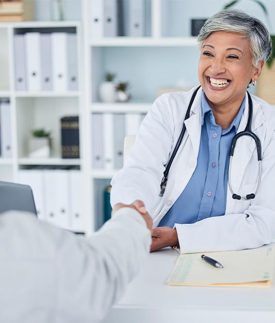 Senior female medical professional shaking hands in interviewee