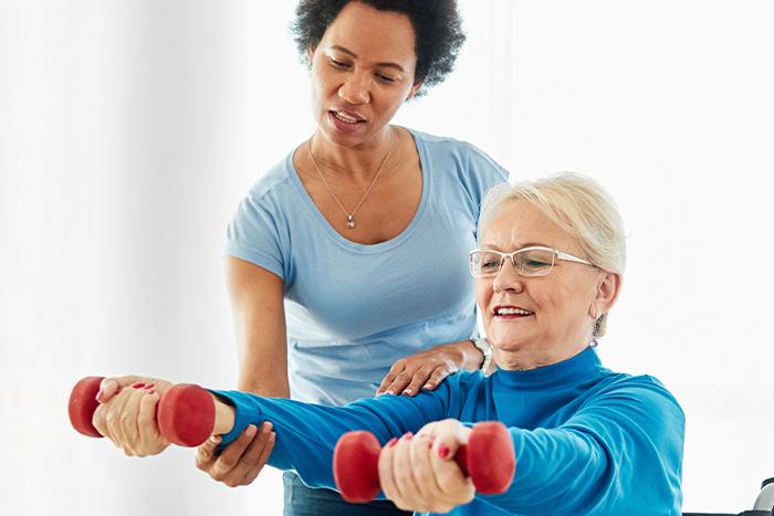 Physical therapist helping patient with weights