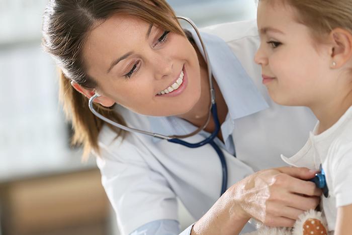 Woman checking a little girls chest with stethoscope