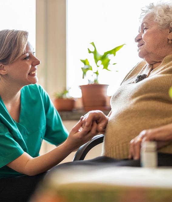 Friendly home health social worker supporting an elderly lady